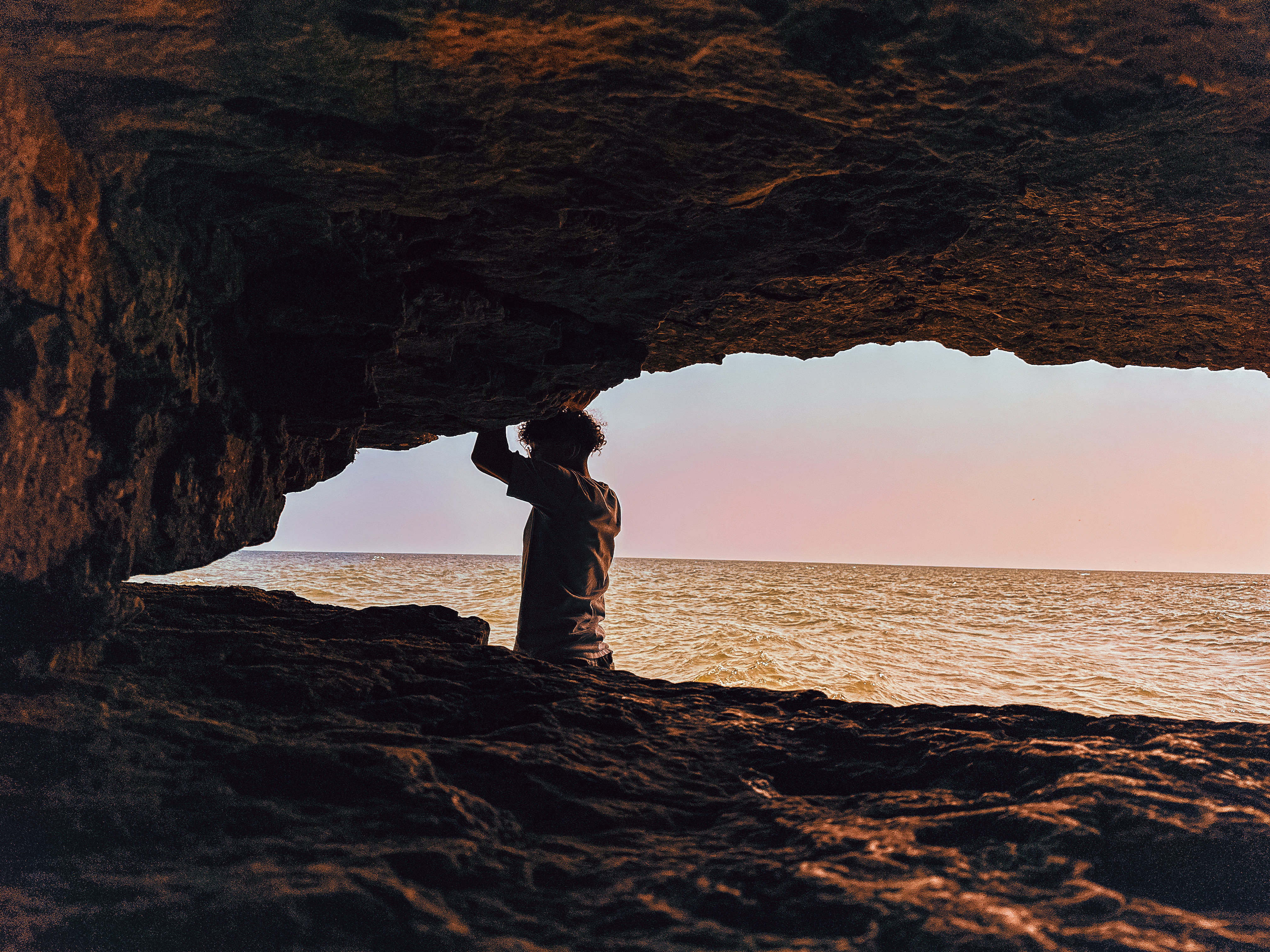 Silhouette in cave opening looking out to the lake